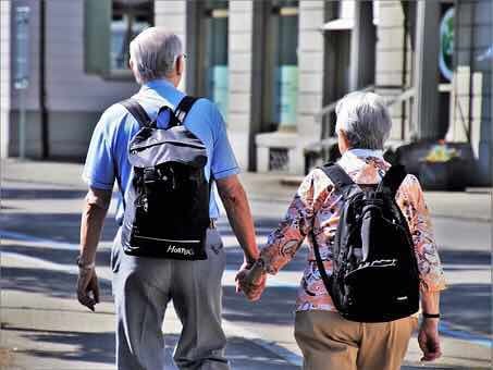 手を繋いで歩いている高齢者夫婦