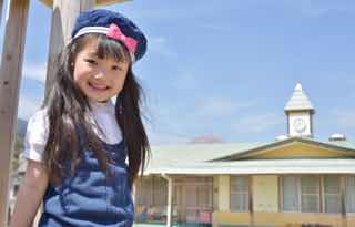 幼稚園前でニコニコ笑顔の女児